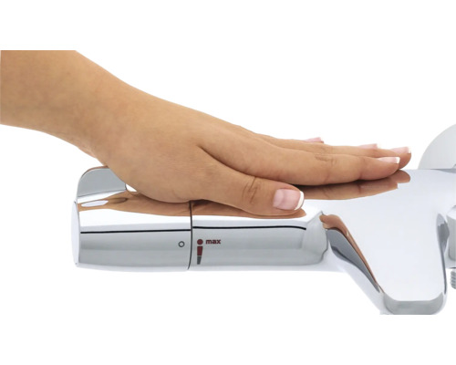 Gros plan d''une main actionnant un robinet chromé avec régulateur de température