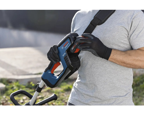 Eine Person wechselt den Akku eines Bosch Akku-Rasentrimmers mit Tragegurt