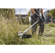 Un homme coupe l''herbe avec un coupe-bordure.