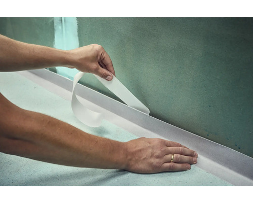 Anwendung von Dichtband im Badezimmer zur Abdichtung von Wand und Boden.