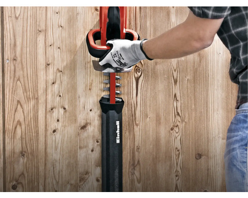 Person mit Handschuhen, die eine Heckenschere von Einhell bedient.