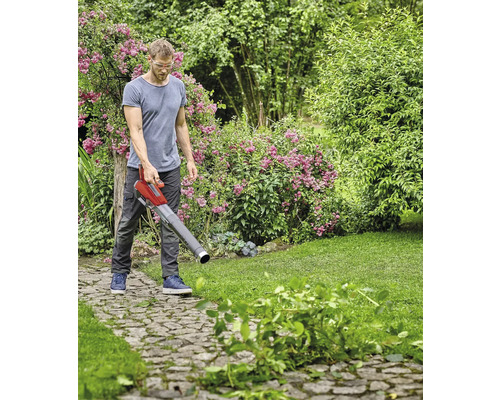 Mann benutzt Laubbläser zur Gartenarbeit