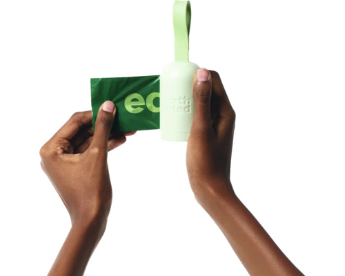 Les mains tiennent un distributeur de sacs à excréments pour chiens et un sac à excréments pour chiens