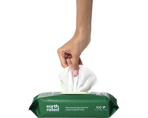 Une main sort une lingette d''un paquet de lingettes nettoyantes pour chiens.