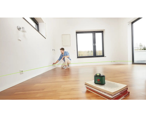 Un homme utilise un laser linéaire dans une pièce pour l''alignement