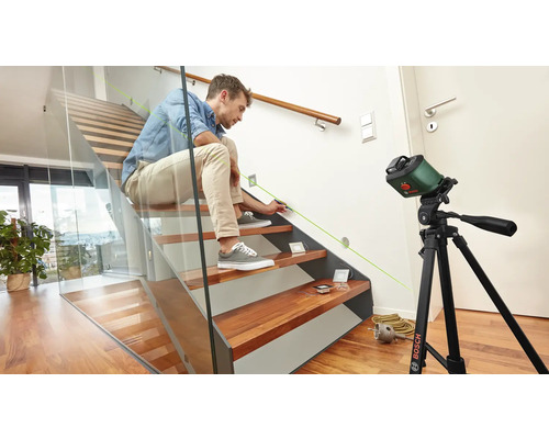 Un homme utilise un laser lignes Bosch sur un escalier pour l''alignement