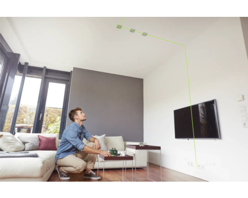 Un homme utilise un niveau laser dans un salon pour l''alignement