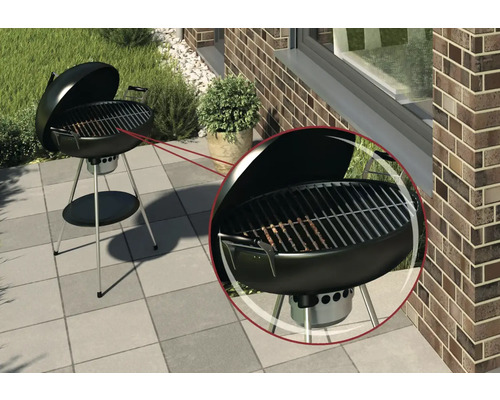 Barbecue boule avec couvercle ouvert sur une terrasse