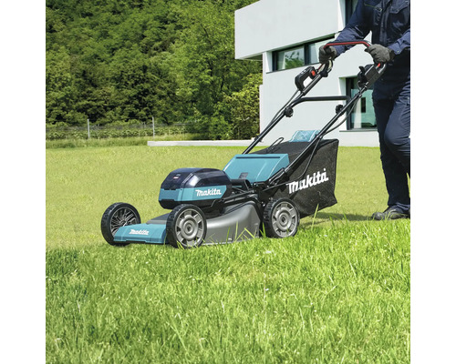 Tondeuse autoportée Makita en cours d''utilisation sur une pelouse.