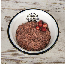 Hundenahrung in einer Schüssel mit Wildes Land Logo und Preiselbeeren