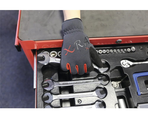 Un chariot à outils avec des clés et une main gantée