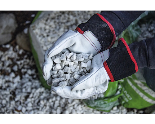 Hände mit Arbeitshandschuhen halten Zierkies