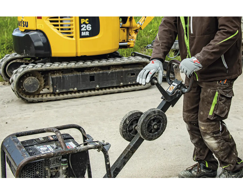 Mann bedient Rüttelplatte vor Minibagger auf Baustelle