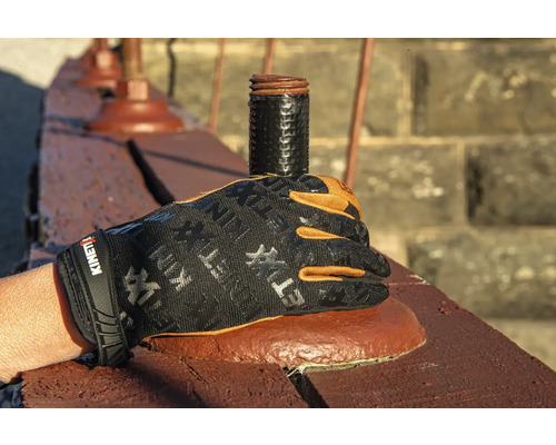 Une main avec un gant de travail tient un tuyau