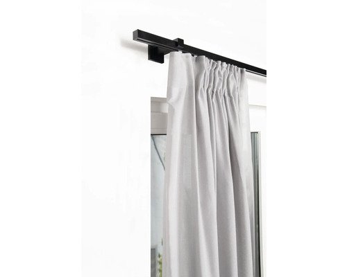 Rideau sur une tringle à rideaux noire devant une fenêtre