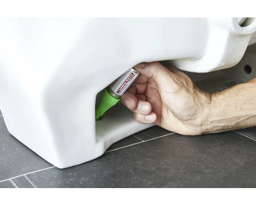 Main scellant les toilettes avec du mastic