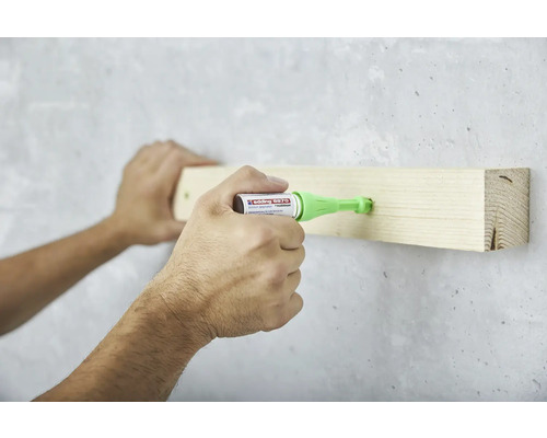 Application du stylo adhésif Edding 8870 pour fixer un morceau de bois sur un mur.