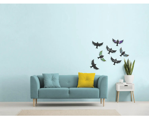 Salon avec canapé, coussins, décoration murale avec motifs d''oiseaux et table d''appoint avec plante