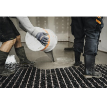 Handwerker gießt Estrich auf eine Fußbodenheizung im Innenbereich.