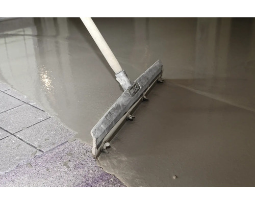 Estrich wird mit einer Rakel aufgetragen