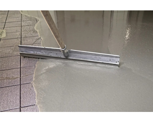 Bodenausgleichsmasse wird mit einer Rakel aufgetragen