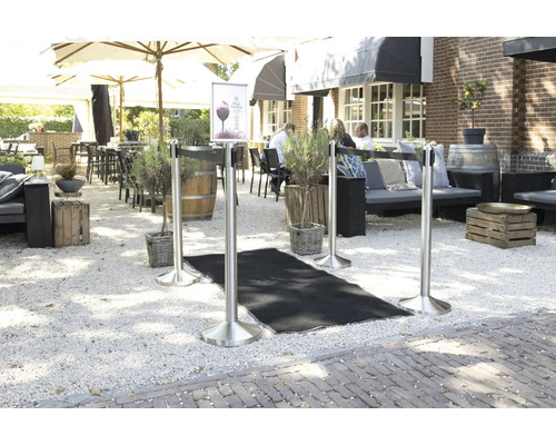 Espace extérieur avec poteaux de délimitation et tapis noir sur gravier