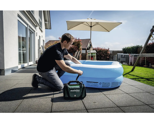 Mann pumpt auf einer Terrasse einen Pool mit einer Metabo Pumpe auf