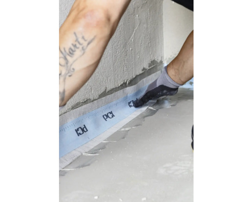 Mann bringt PCI Dichtband an Wand an