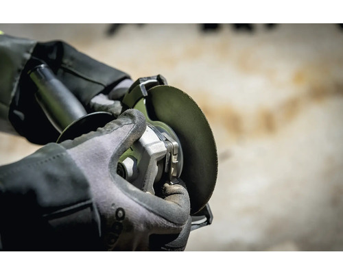 Vue d''une personne travaillant avec une meuleuse d''angle et portant des gants de protection