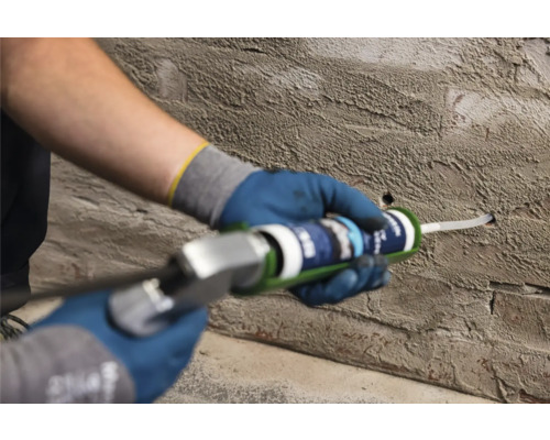 Handwerker füllt ein Loch in einer Wand mit Dichtstoff