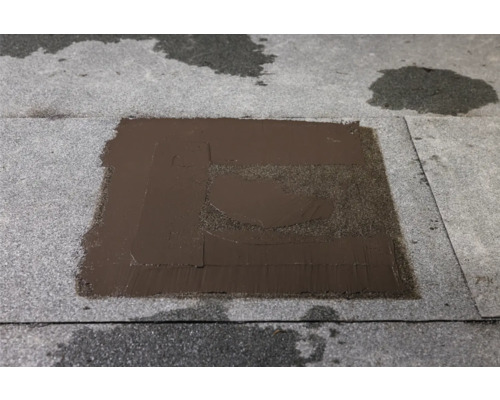 Reparaturstelle mit Bitumenanstrich auf einer Dachpappe