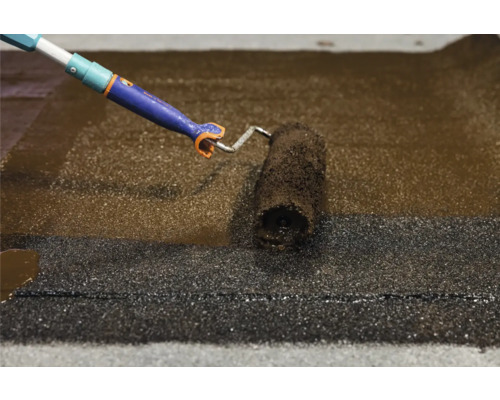 Dachbeschichtung wird mit einer Farbwalze aufgetragen.