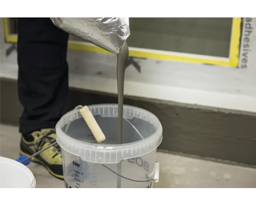 Ausgießen von Nivelliermasse in einen Eimer