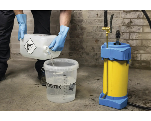 Eine Person gießt Flüssigkeit aus einem Behälter mit Gefahrensymbol in einen Eimer, neben einem Sprühgerät.