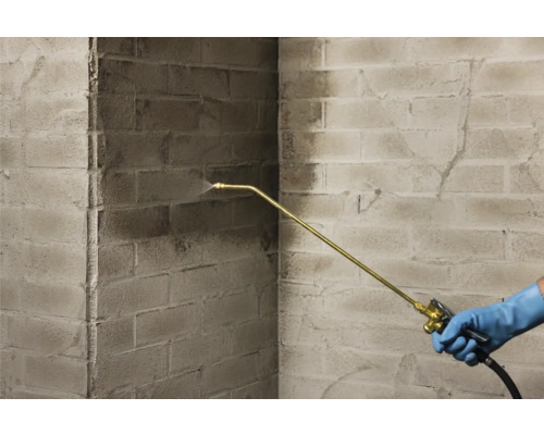 Aussenaufnahme einer Steinmauer, die mit einem Sprühgerät gereinigt wird