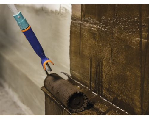 De la peinture est appliquée sur un mur avec un rouleau à peinture.