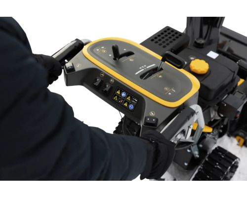 Nahaufnahme der Bedienelemente einer Schneefräse mit Hinweisschildern