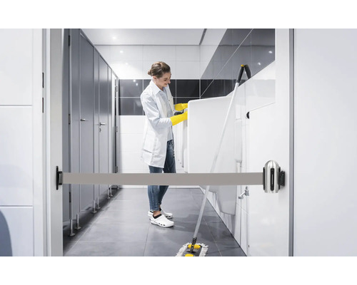 Reinigungskraft reinigt Badezimmer mit Absperrband