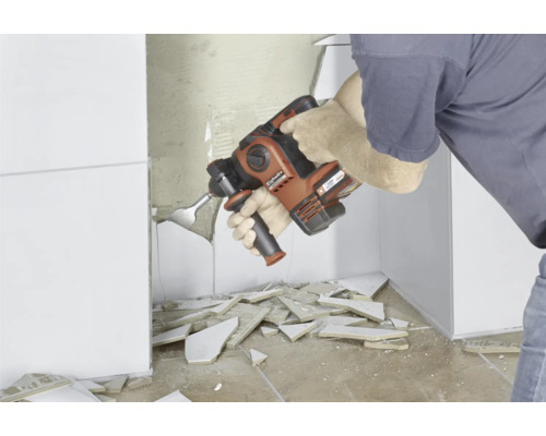 Un homme retire des carreaux avec un marteau-piqueur Einhell