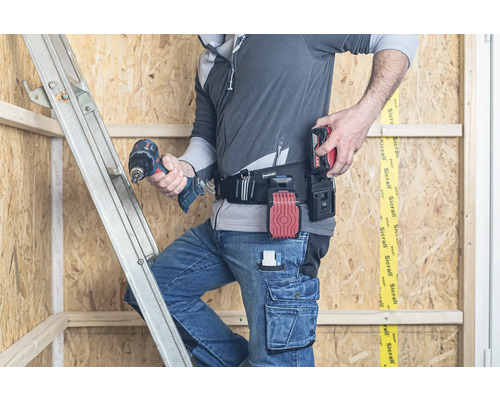 Handwerker auf einer Leiter mit Werkzeugtasche und Akkuschrauber
