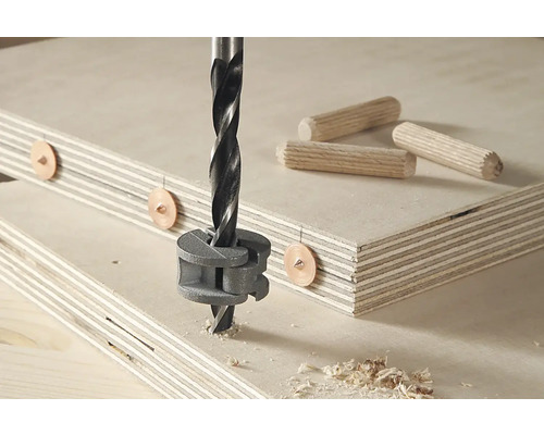 Mèche à tourillons en utilisation avec des pointes à tourillons et des tourillons en bois sur une plaque de bois