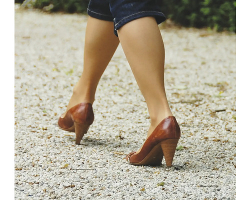 Femme marchant sur du gravier avec des chaussures en cuir à talons