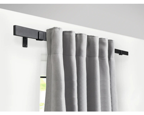 Tringle à rideaux avec rideaux gris sur le mur