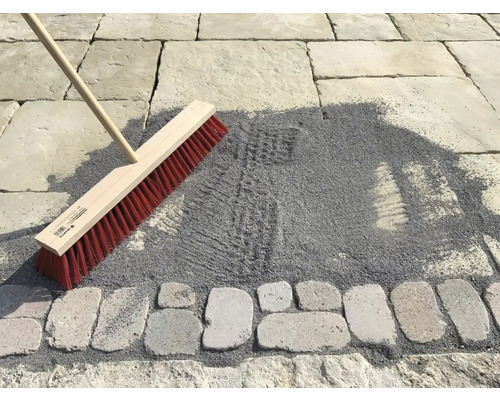 Besen zum Einkehren von Pflastersand auf einer gepflasterten Fläche