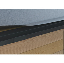 Nahaufnahme einer schwarzen Rasenkante aus Metall an einer Hauswand mit Holzboden