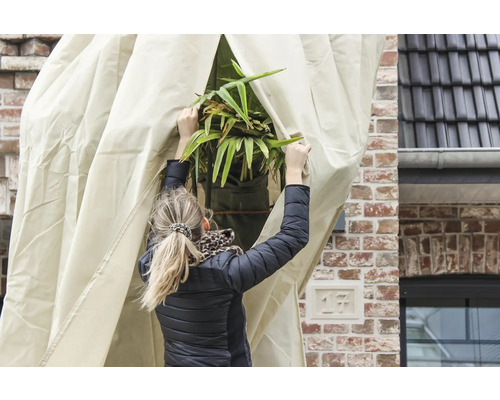 Frau öffnet eine Schutzhülle für Pflanzen im Außenbereich