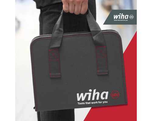 Person hält eine graue Wiha Werkzeugtasche mit roten Akzenten