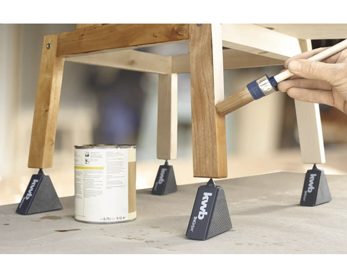 Tabouret en bois peint avec de la peinture et un pinceau, soutenu par des pyramides à meubles