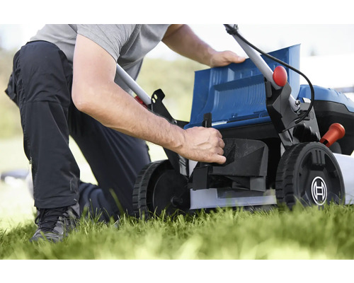 Eine Person bereitet einen Rasenmäher für die Gartenarbeit vor