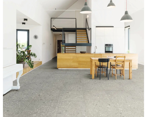 Heller Wohnraum mit grauen Bodenfliesen, Küchentisch und Treppe